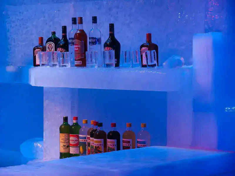 Innenansicht der ICEBAR Stockholm mit aus Eis geschnitzten Wänden und blauer Beleuchtung